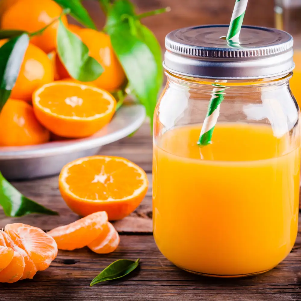 Jarra de zumo natural de mandarina con mandarinas frescas de Valencia.